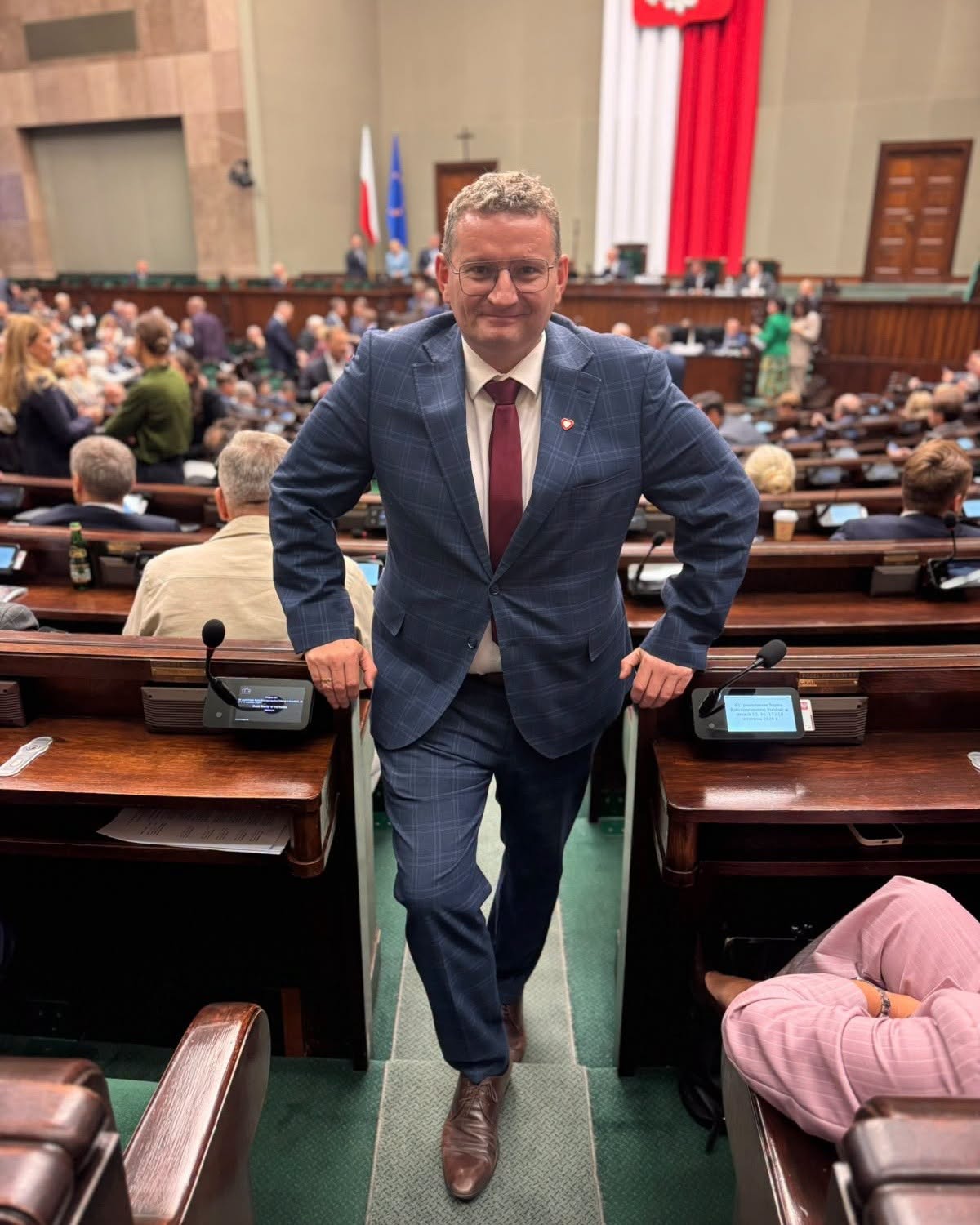 Bartosz Zawieja na sali plenarnej Sejmu, w przejściu między ławami poselskimi